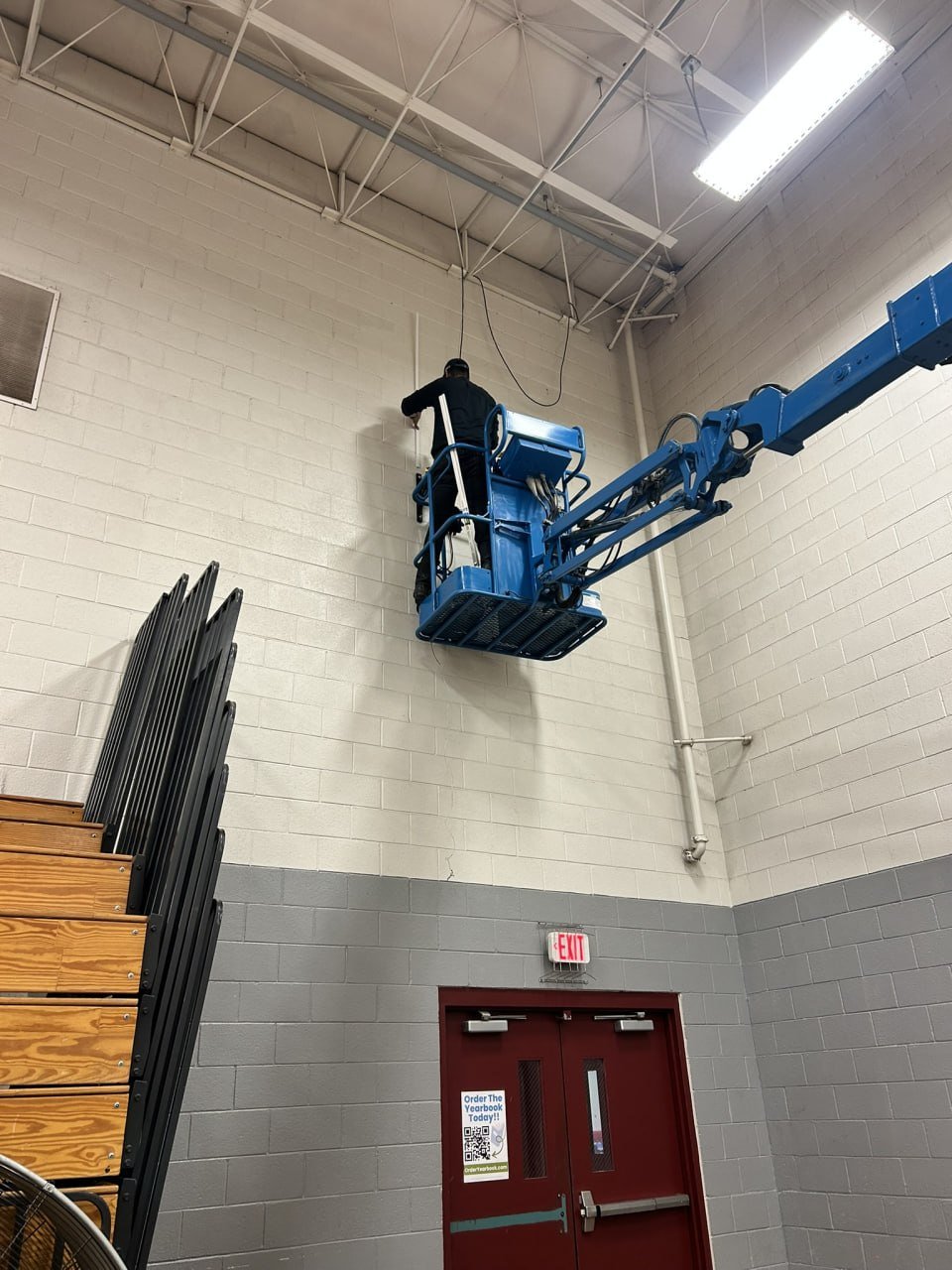 Alan Mungaray on boom lift installing SLMS gym speakers